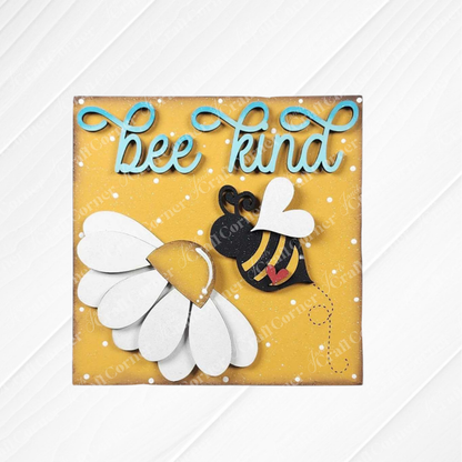 Bee Swappable Squares by Janet's Craft Corner: A handmade card with a bee and daisy on yellow, blue "bee kind" script,  white dots on the background, and a shaded border—charming for gifts or cheerful decor.