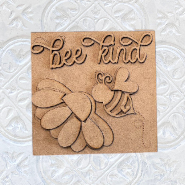 Janet’s Craft Corner’s Bee Swappable Squares is a DIY wooden kit with a bee, heart wings, and "bee kind" in cursive on an embossed white background—perfect for creative crafting enthusiasts.