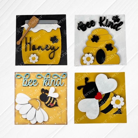 The Bee Swappable Squares DIY kit by Janet's Craft Corner includes four burlap-backed designs—a bee, a honey jar labeled "Honey," a beehive, and "bee kind" text—arranged on a textured white tile for charming home decor.