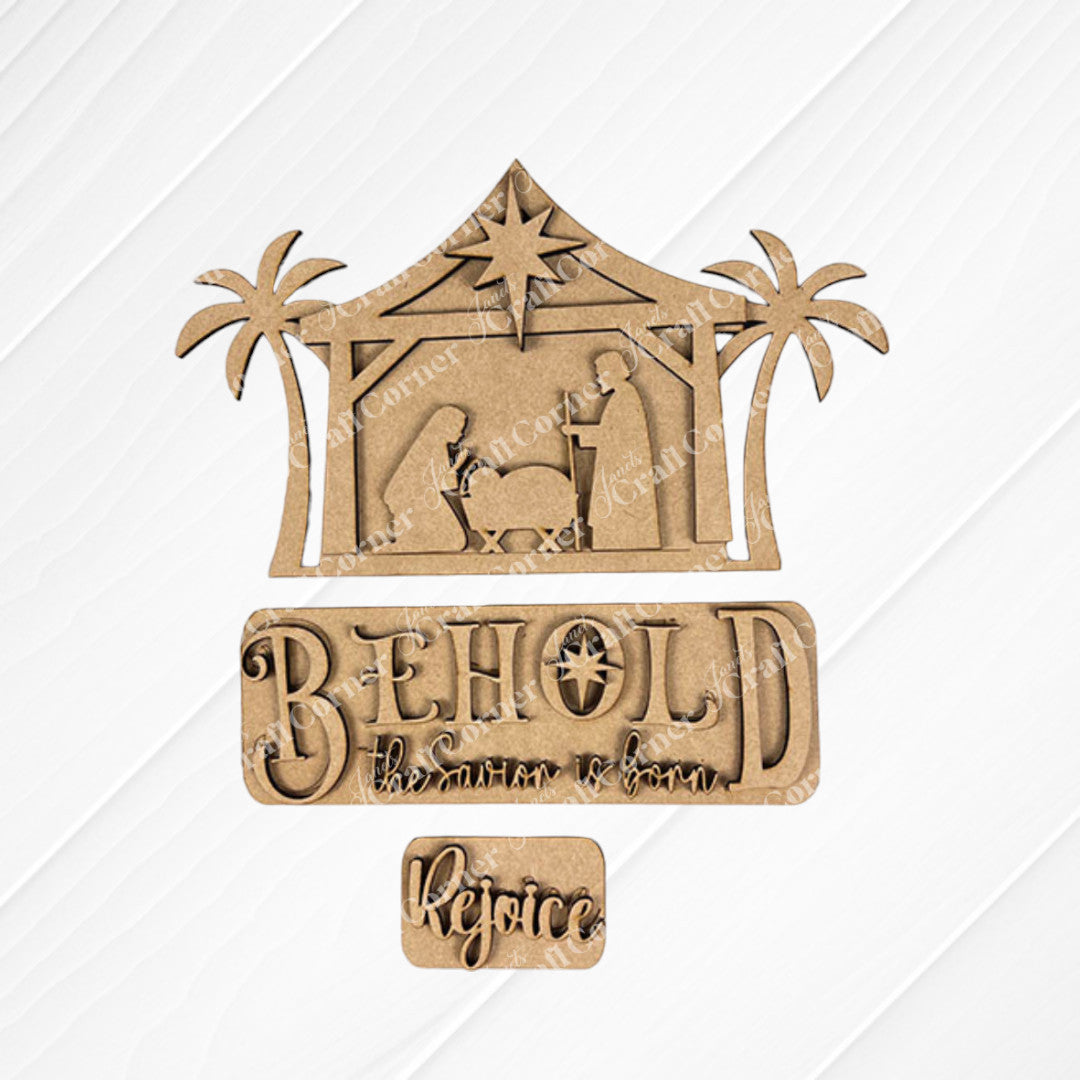 Introducing the Nativity Interchangeable Insert by Janet's Craft Corner, a DIY home decor kit featuring a hand-painted wooden nativity scene with Mary, Joseph, and baby Jesus cradled in a manger framed by palm trees. This versatile decor set includes interchangeable text options: "Behold, the Savior is born" and "Rejoice," displayed on an elegant background to bring warmth and charm to any space.