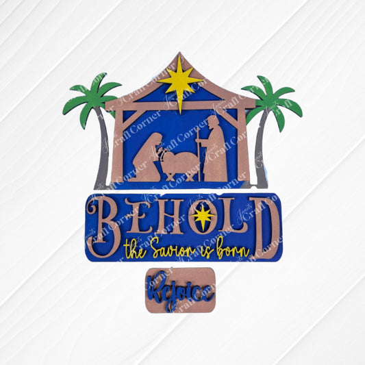 The Nativity Interchangeable Insert from Janet's Craft Corner is an exquisite DIY home decor kit, showcasing a hand-painted scene of Mary, Joseph, and baby Jesus in a manger under a radiant star with palm trees. The piece features the inspiring phrases "Behold, the Savior is born" and "Rejoice," all set against a beautifully textured background.