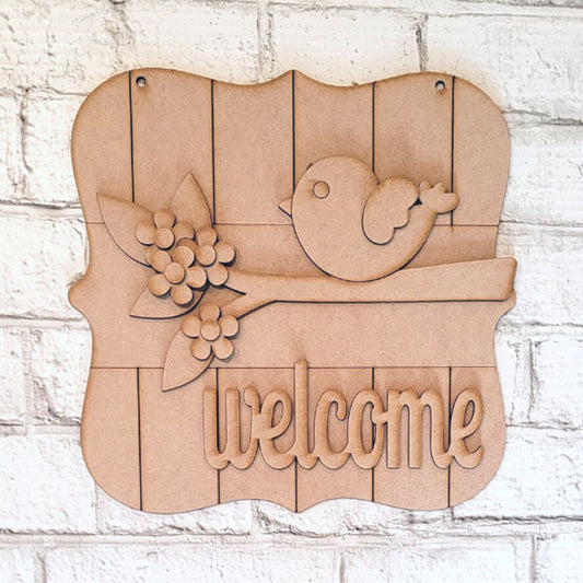The Bird Welcome Sign by Janet's Craft Corner decorates the brick wall with a charming bird on a branch with flowers. "Welcome" is carved at the bottom of this rustic wooden plaque, ideal for any entryway. Available as a DIY seasonal home decor craft kit in a set of 1.