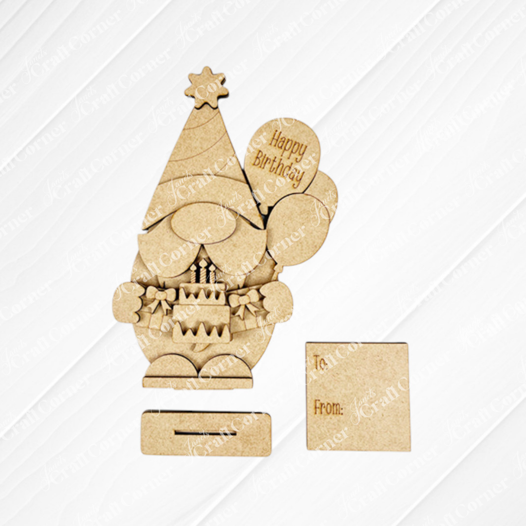 The Birthday Gnome Shelf Sitter from Janet's Craft Corner is a delightful wooden cutout featuring a gnome with balloons and a cake. One balloon reads "Happy Birthday." It includes a detachable base and has a small plaque for "To:" and "From:", perfect for home décor or DIY crafting.