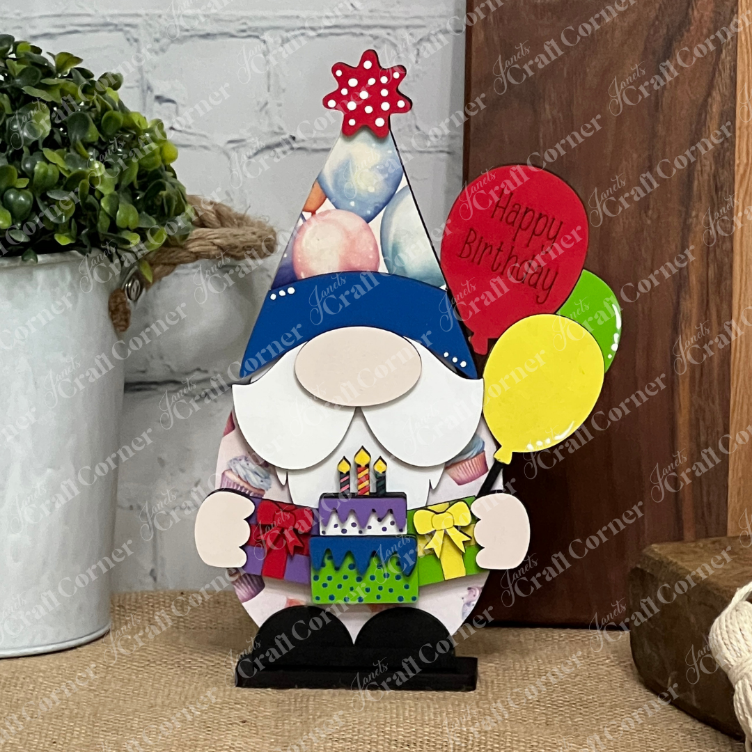 The Birthday Gnome Shelf Sitter by Janet's Craft Corner is a DIY home decor craft kit featuring a gnome with balloons (one says "Happy Birthday"), gifts, and cake—perfect as a charming rustic accent for your shelf or table. Set of 1 included.