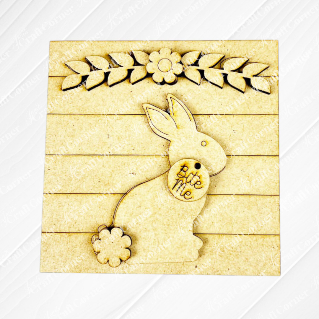 Janet's Craft Corner Easter Bunny Squares feature a sitting bunny with a fluffy tail and "bite me" tag under leafy branches on wood slats—ideal for spring or Easter tiered tray Swappable Square Displays.