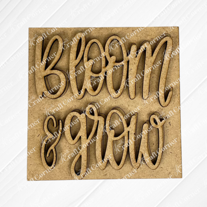 The Bloom & Grow Squares by Janet's Craft Corner features a laser-cut, light brown wood sign with "bloom & grow" in cursive and a subtle white diagonal pattern—perfect for tiered tray decor or Swappable Squares displays.