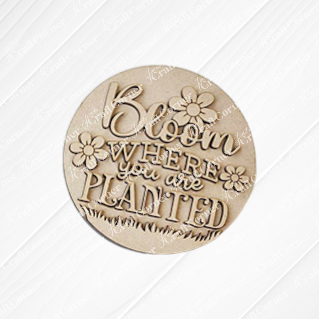 The Hello Spring Decor Set - DIY Craft Kit (5 pieces) by Janet's Craft Corner features round wooden farmhouse-style plaques with floral designs and "Bloom where you are planted" engraving—perfect for spring décor or DIY projects.