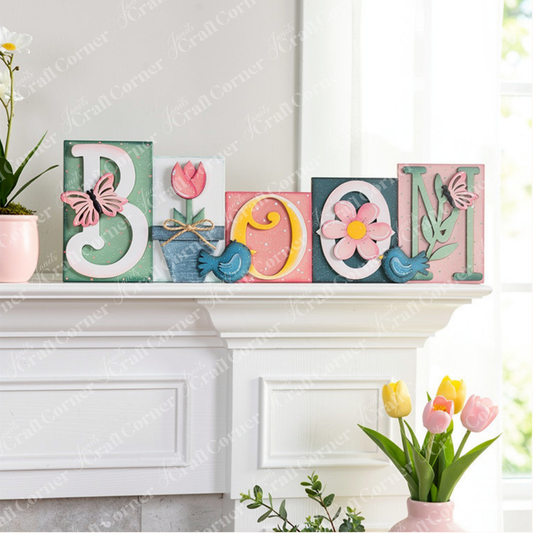 The Bloom Word Block by Janet's Craft Corner spells "BLOOM" with charming floral and butterfly motifs, including a tulip, daisy, and pastel-colored butterflies. This piece is perfect for enhancing home décor against a white wooden wall.