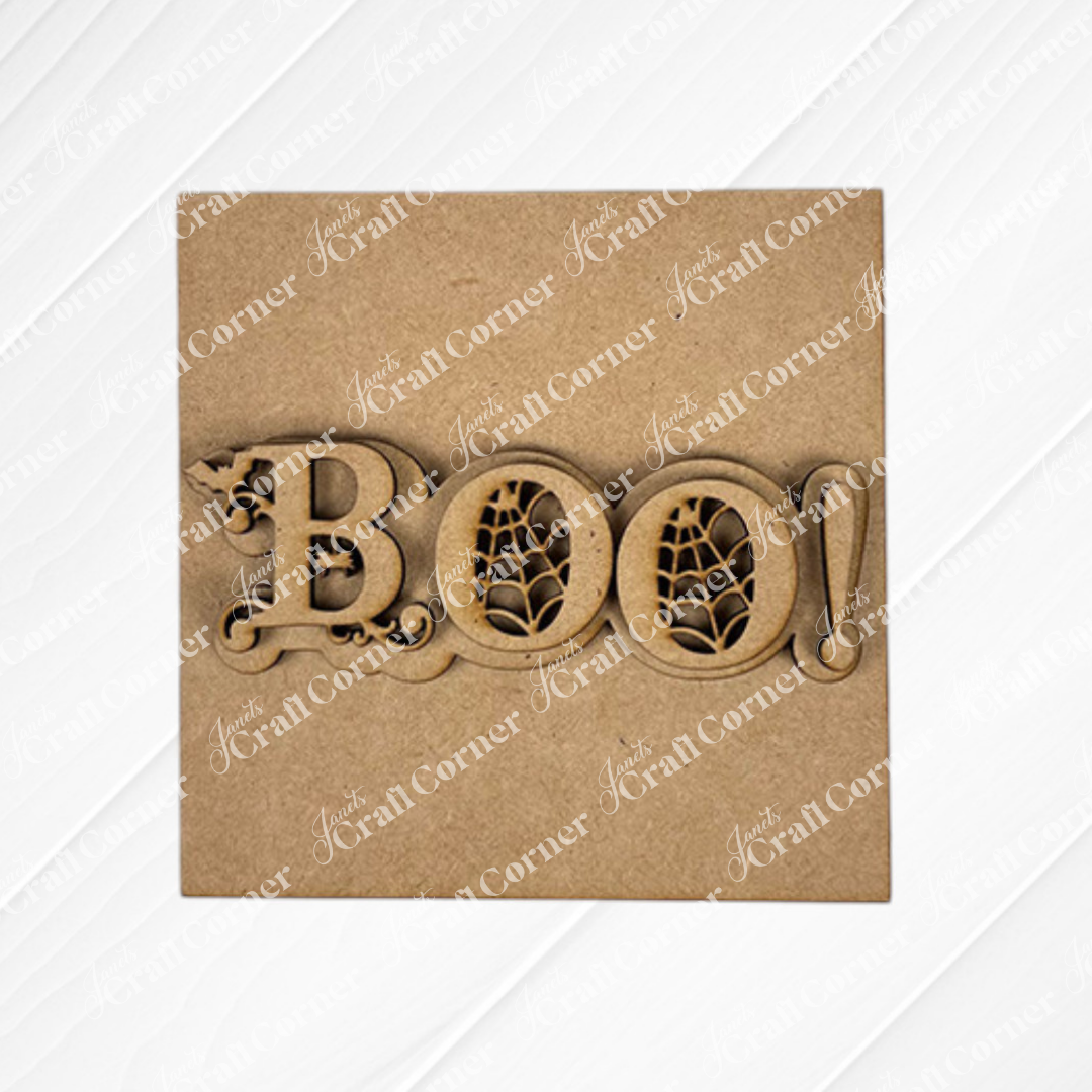 Halloween Squares by Janet's Craft Corner features a decorative wooden "BOO!" sign with spiderweb designs in the O’s, ideal for tiered tray decor or pairing with wood cut-outs, shown on a plain brown background.