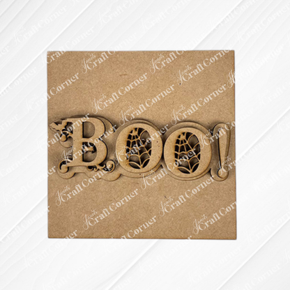Halloween Squares by Janet's Craft Corner features a decorative wooden "BOO!" sign with spiderweb designs in the O’s, ideal for tiered tray decor or pairing with wood cut-outs, shown on a plain brown background.