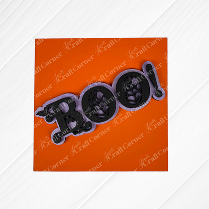 Janet's Craft Corner Halloween Squares feature a "Boo!" cake topper in a ghostly font with black letters outlined in white on an orange background—ideal for tiered tray decor or pairing with wood cut-outs for festive Swappable Squares.