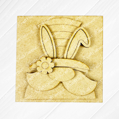 Hello Easter Squares by Janet's Craft Corner is a square wooden cutout with a whimsical bunny-ear hat and flower detail in layered, unfinished wood—perfect for DIY craft lovers and fans of unique wood cut-outs.