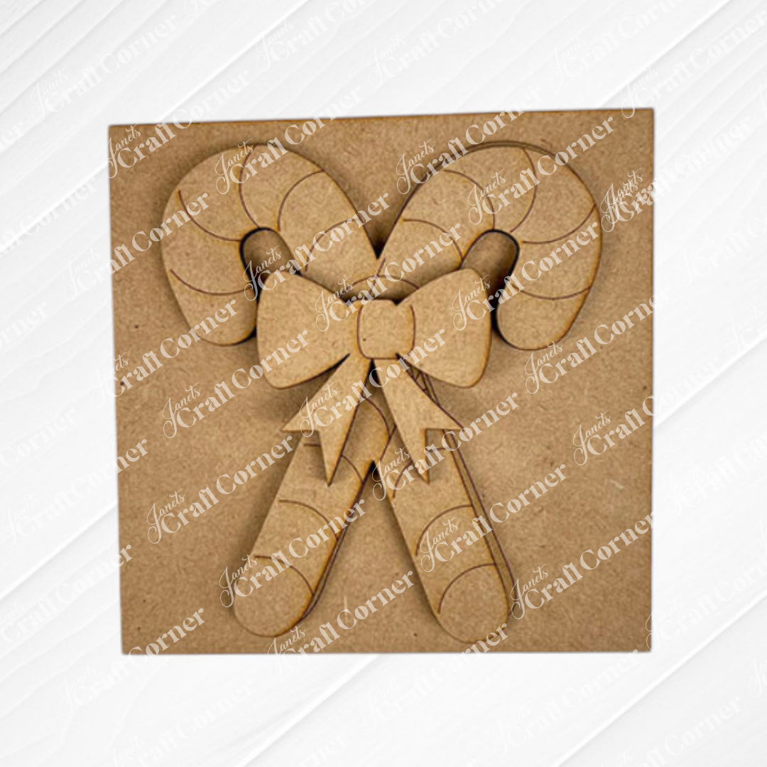 Janet's Craft Corner's Christmas Icon Swappable Squares DIY kit features a laser-cut cardboard decoration of two crossed candy canes with a bow, perfect for seasonal home decor or adding to your swappable square signs.