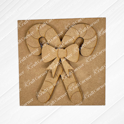 Janet's Craft Corner's Christmas Icon Swappable Squares DIY kit features a laser-cut cardboard decoration of two crossed candy canes with a bow, perfect for seasonal home decor or adding to your swappable square signs.