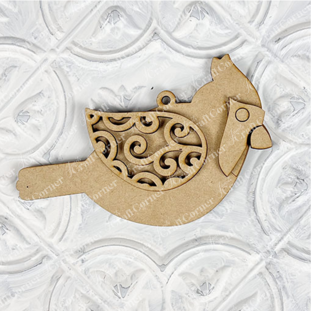 Introducing the Cardinal Ornament from Janet's Craft Corner—a DIY decoration kit featuring a cardinal bird crafted from wood, adorned with intricate swirl patterns on its wings and set against a white embossed, patterned background. Ideal for holiday décor or as a hand-painted craft project.