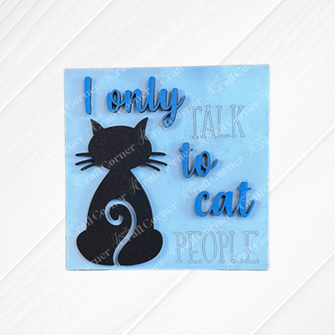 Janet's Craft Corner Cat Swappable Squares feature square sign with a black cat silhouette and "I only talk to cat people" in blue—ideal DIY home decor for small spaces, shown with plants, a candle, and wood accents.