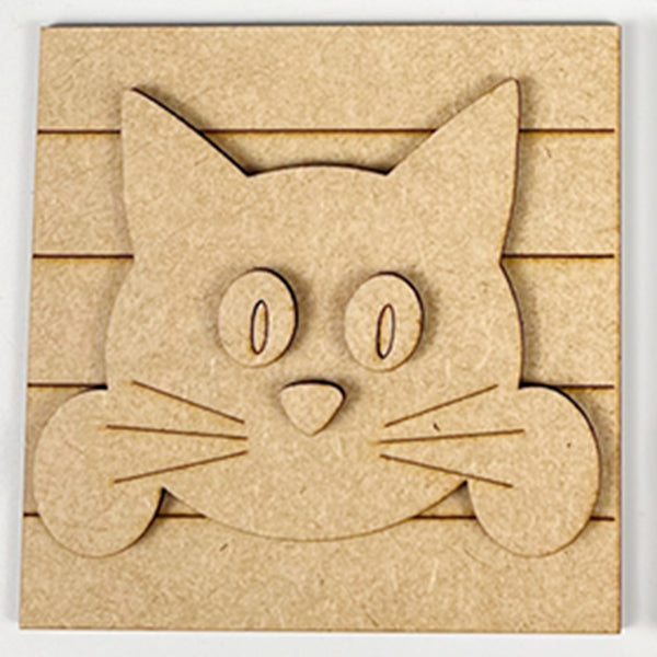 The Cat Swappable Squares by Janet's Craft Corner features a wooden cartoon cat face with big oval eyes, pointy ears, and whiskers on a grooved square—ideal for tiered trays or DIY seasonal home decor projects.