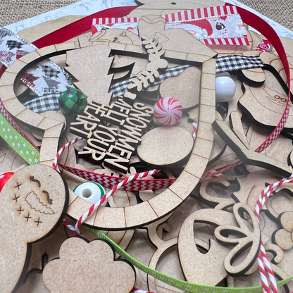 A mix of unfinished wooden Christmas ornaments, ribbons, beads, and candy decorations—ideal for your next Crafted by You! Subscription DIY home decor craft kit from Janet's Craft Corner.