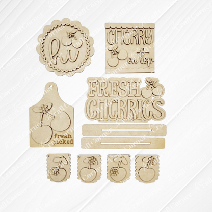 Janet's Craft Corner Cherry Decor Set includes laser-cut unfinished wood shapes with phrases like "hi," "CHERRY on top," and cherry designs, ideal for farmhouse tags or DIY home decor, all displayed on a white background.