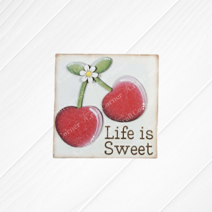 The Cherry Squares DIY seasonal home decor craft kit by Janet's Craft Corner features two red cherries, a green stem, a white daisy, and "Life is Sweet" on a light striped background—ideal for tiered trays or Swappable Squares collections.