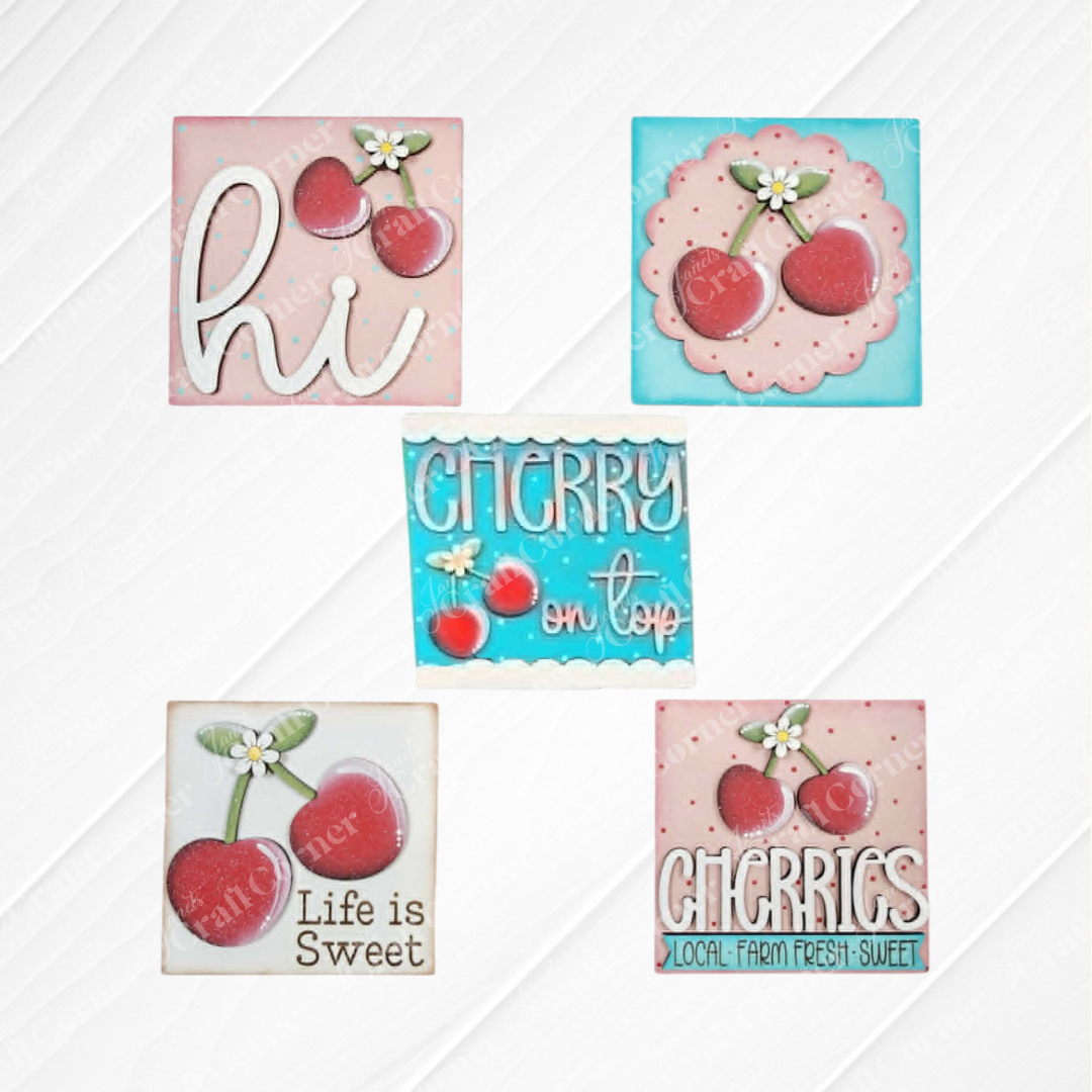 Cherry Squares DIY craft kit by Janet's Craft Corner features five decorated cookies with cherry designs and sweet messages—perfect as Swappable Squares or tiered tray decor, set on a white textured background.