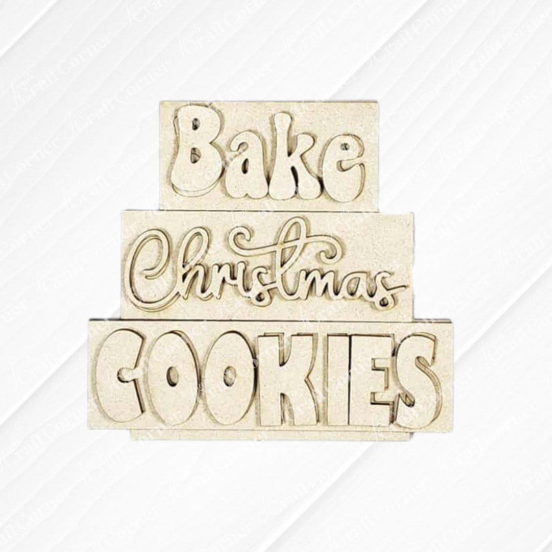 Janet's Craft Corner’s Christmas Baking Mini Shelf Sitters DIY kit features three stacked blocks with “Bake Christmas Cookies” in playful fonts—perfect as festive holiday décor or a charming seasonal craft project.
