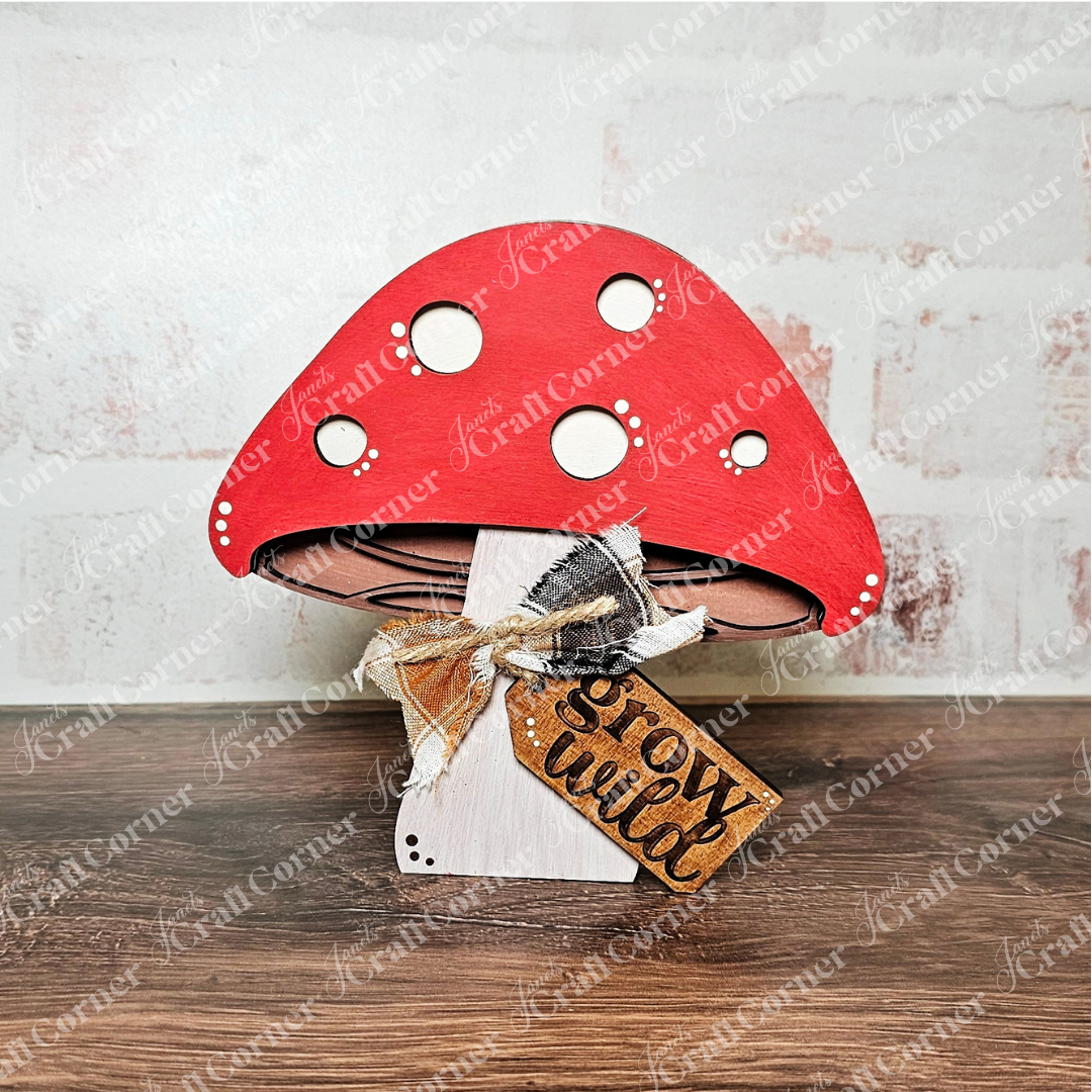 The Fall Chunky Mini Shelf Sitters DIY kit by Janet's Craft Corner includes a wooden mushroom with a red cap, white spots, plaid bow, and "grow wild" tag—ideal for autumn decor or crafts. Choice of 3 designs available.
