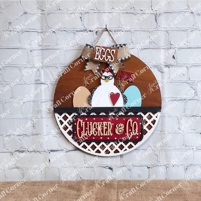 Janet's Craft Corner introduces the Clucker & Co. Interchangeable Insert - Painted, a decorative piece featuring a delightful chicken motif adorned with glasses, alongside a red heart and colorful eggs. The sign displays "EGGS" and "Farm Fresh" at the top, with "Clucker & Co." beneath on a rustic lattice background, making it an ideal choice for farmhouse decor enthusiasts seeking versatile craft inserts.