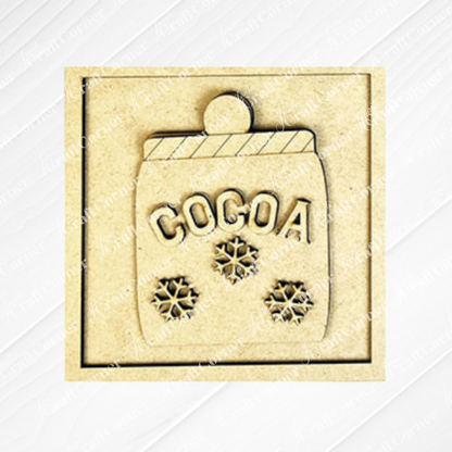 The Hot Cocoa Squares plaque by Janet's Craft Corner is a gold-toned square featuring a "COCOA" mug with a striped rim and three snowflakes, ideal for DIY seasonal home decor.
