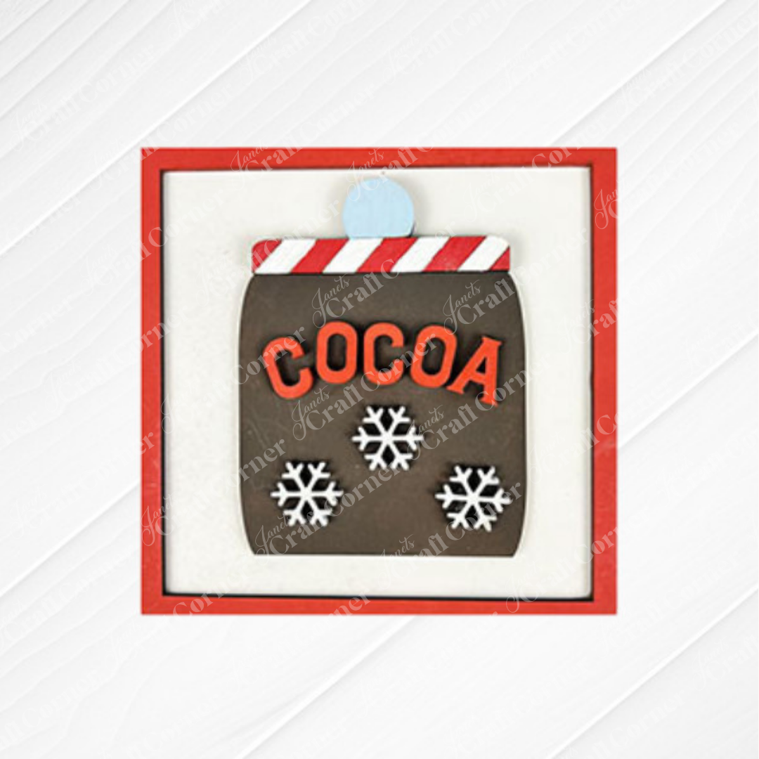 The Hot Cocoa Squares cookie from Janet's Craft Corner features a cocoa mug with "COCOA" and snowflakes in a red square frame—perfect for seasonal DIY home decor or festive craft kit inspiration.