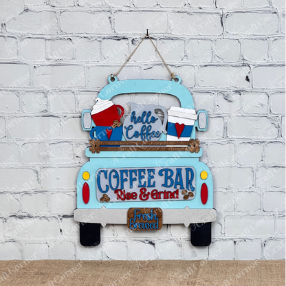 This charming home décor piece, by Janet's Craft Corner, features an antique truck base with a DIY interchangeable wooden red truck insert. Decorated with "Coffee Bar" and "Fresh Brewed" signs, coffee mugs, and hearts against a white brick wall, it's surrounded by cutting boards, a plant, and a candle.