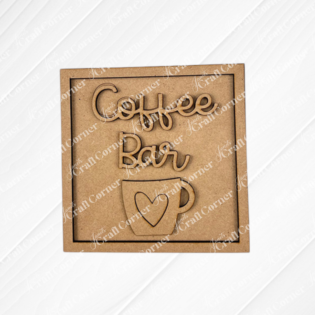 The Coffee Bar Swappable Squares DIY craft kit from Janet's Craft Corner features a wooden sign with "Coffee Bar" above a coffee cup with a heart—perfect for your next coffee-inspired project or seasonal home decor makeover.