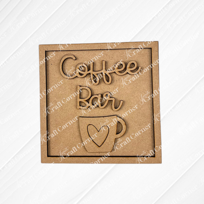 The Coffee Bar Swappable Squares DIY craft kit from Janet's Craft Corner features a wooden sign with "Coffee Bar" above a coffee cup with a heart—perfect for your next coffee-inspired project or seasonal home decor makeover.