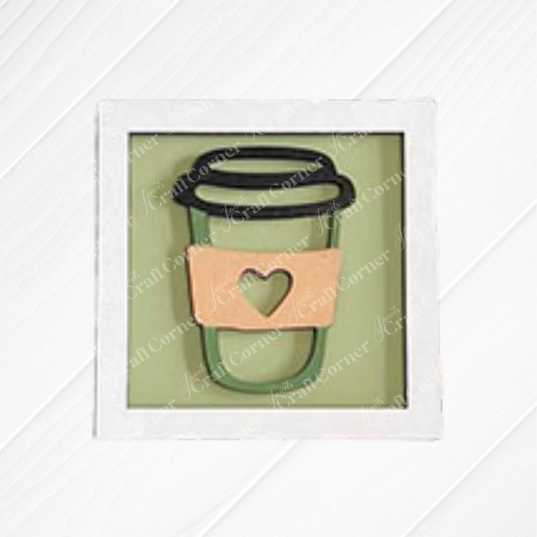 Coffee Bar Swappable Squares by Janet's Craft Corner: a framed drawing of a coffee cup with a coral sleeve and green heart, displayed on a white wood background.