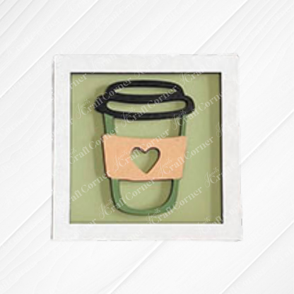 Coffee Bar Swappable Squares by Janet's Craft Corner: a framed drawing of a coffee cup with a coral sleeve and green heart, displayed on a white wood background.