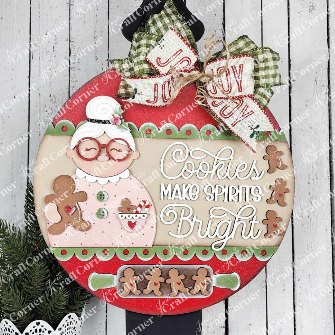 The Cookies Make Spirits Bright Wall Hanger by Janet's Craft Corner features a gingerbread grandma, cookies, and festive accents—perfect DIY holiday decor to brighten your home.