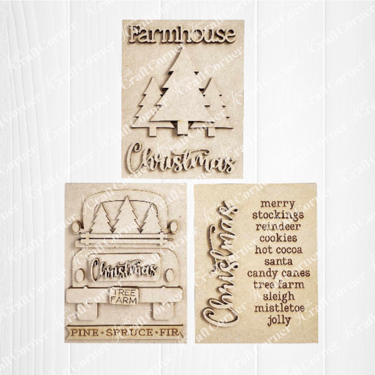 Displayed against a white plank wall this set of Country Christmas Switchable Farmhouse Signs are DIY seasonal home decor kits with a country Christmas theme. One features the wood cut-out word “Christmas” with words that evoke the holiday season, another features a set of three Christmas trees and the last features an antique truck with the word Christmas on its tailgate and trees in its bed.