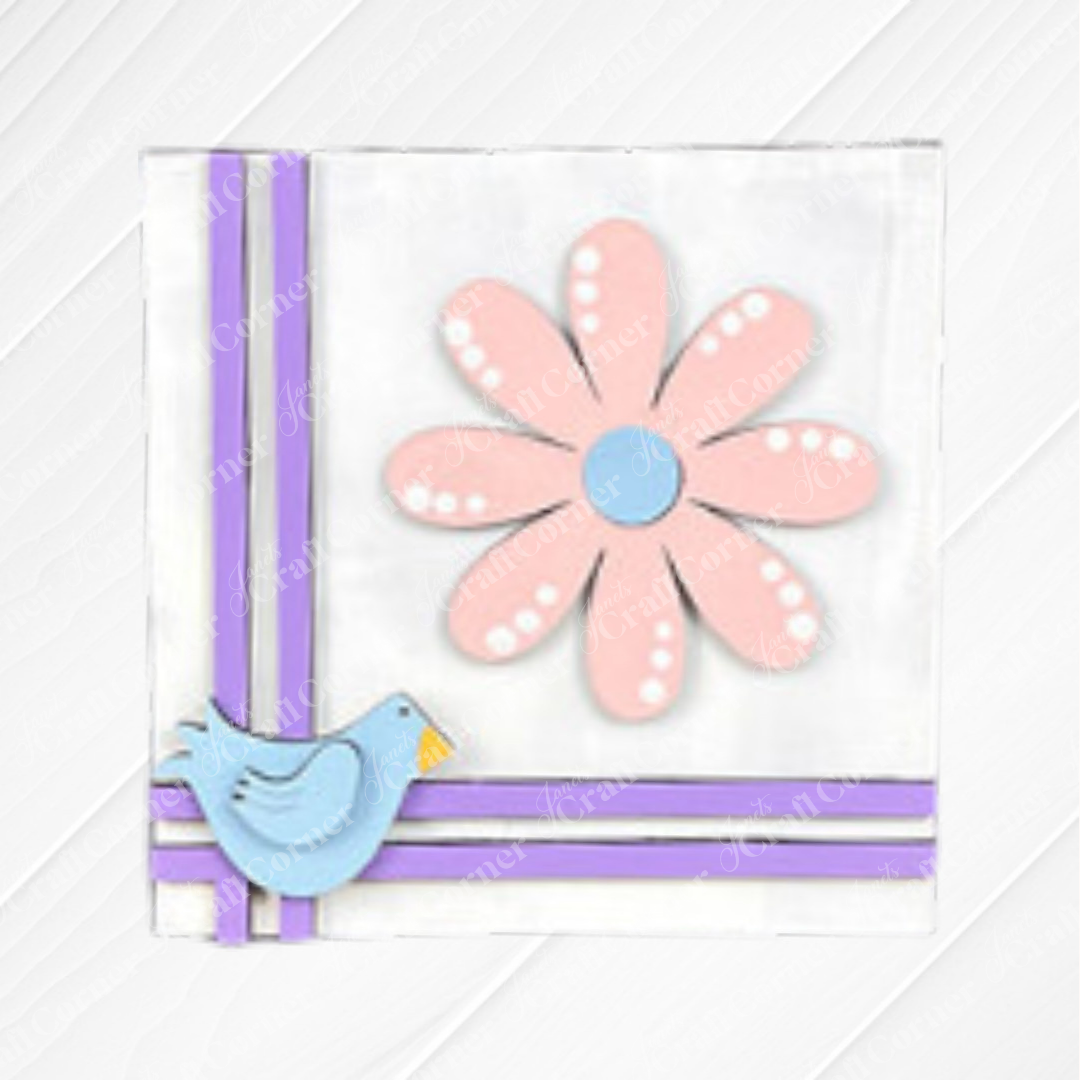 The Bloom & Grow Squares by Janet's Craft Corner is a white square card for tiered tray decor, featuring a large pink flower, a small blue bird in the lower left, and two purple stripes along the left and bottom edges.