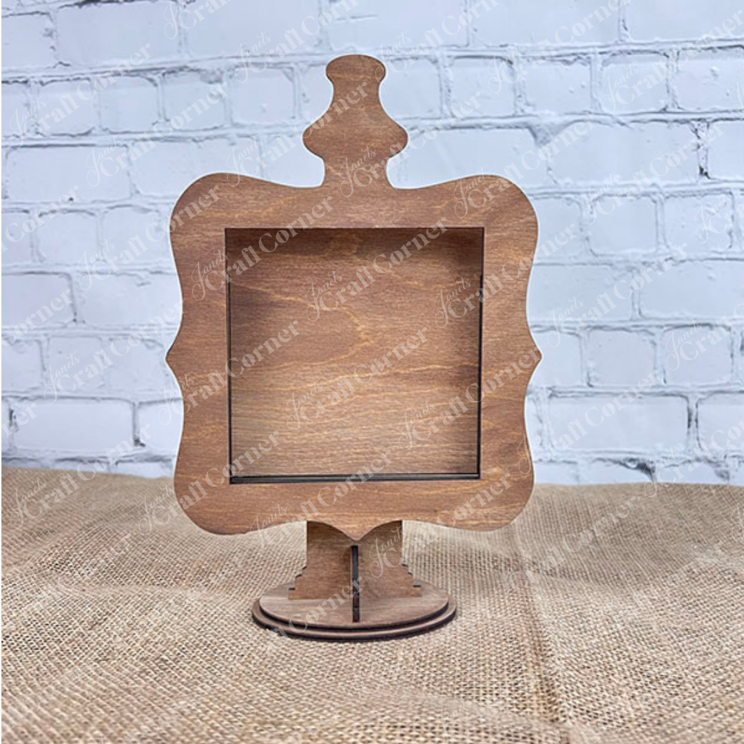 The Heartland Drop In Swappable Squares Holder - DIY Craft Kit (Set of 1) is a wooden, ornate sign holder with a stand, ideal for home décor displays and perfect for adding your own custom signs.
