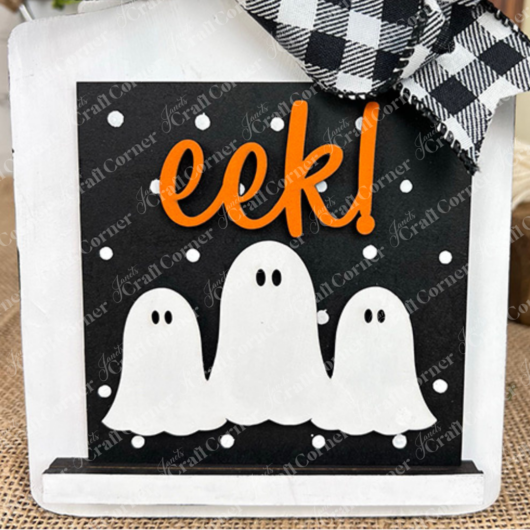 Halloween Squares by Janet's Craft Corner features three cartoon white ghosts on a black background with white dots, "eek!" in bright orange, and a black-and-white checkered bow. Perfect for tiered tray decor this Halloween!.