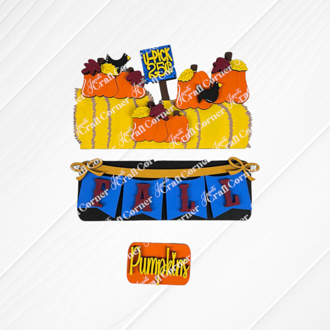 A set of beautifully decorated cookies displayed on a woven mat captures the essence of fall décor with designs featuring pumpkins, hay bales, and crows. One cookie displays the message "U-Pick 25¢" in a cozy autumn atmosphere, perfectly embodying the style of Janet's Craft Corner's Fall Hay Bale Interchangeable Insert - Painted. This scene brings an interchangeable home decor touch to your seasonal festivities.
