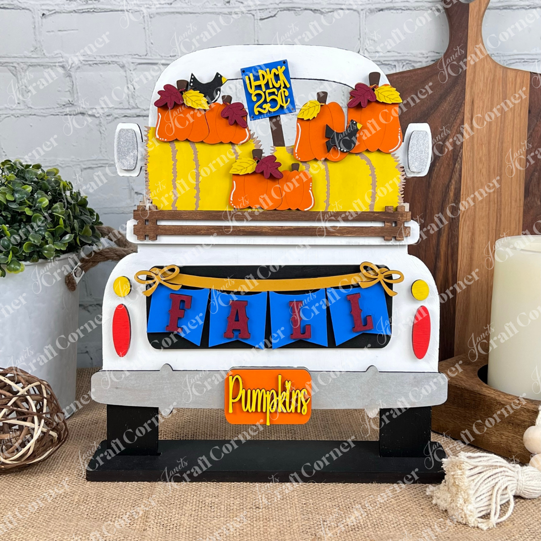 The Antique Truck Base with Insert by Janet's Craft Corner features a rustic truck adorned with colorful pumpkins, a "FALL" banner, and "Pumpkins" and "Pick of the Patch" signs, perfect for DIY home décor lovers.