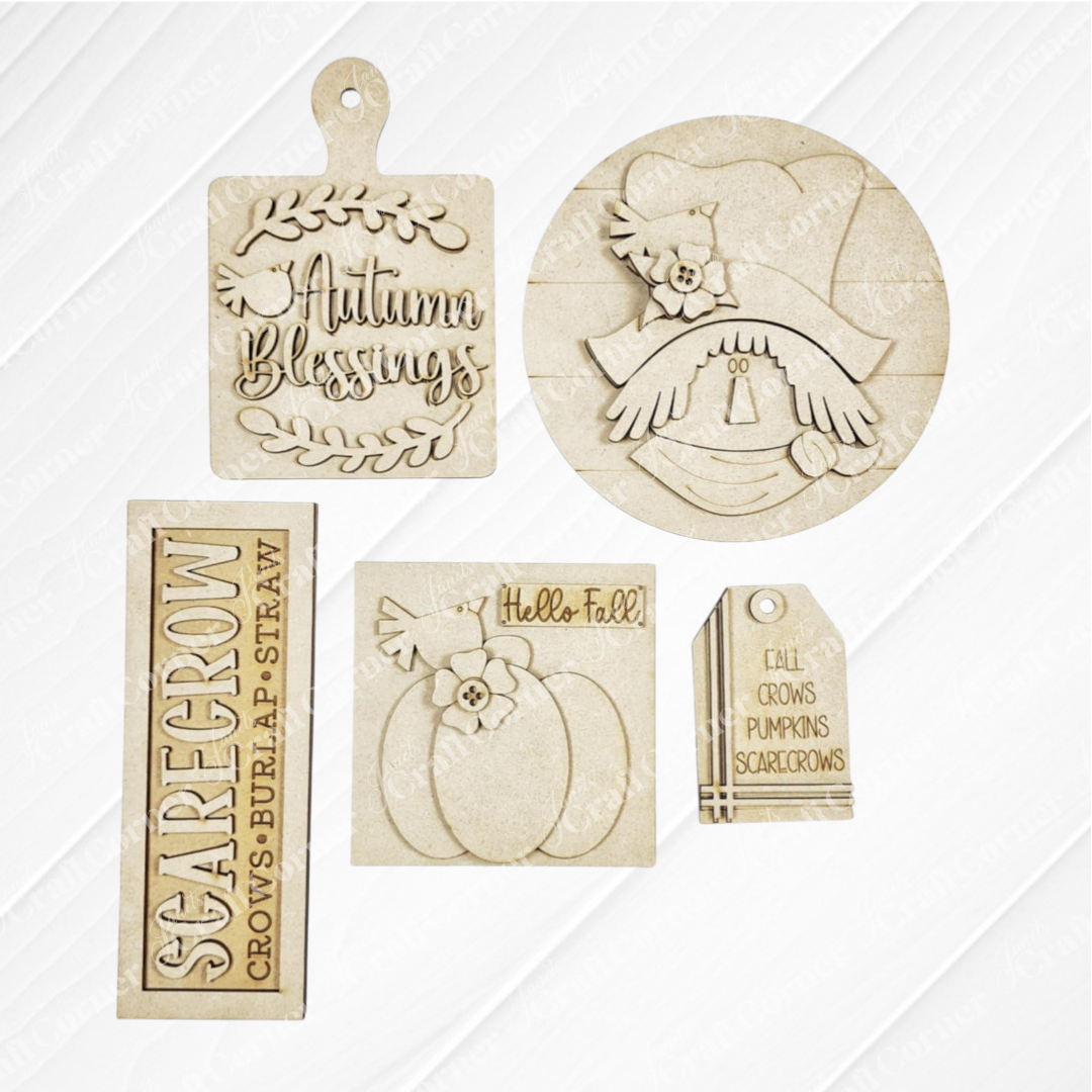 Janet's Craft Corner Fall Scarecrow Mini Shelf Sitters DIY craft kit includes five unfinished wood cutouts: Autumn Blessings, scarecrow face, pumpkin, Hello Fall!, and a scarecrow tag—perfect for autumn home decor. Set of 1.