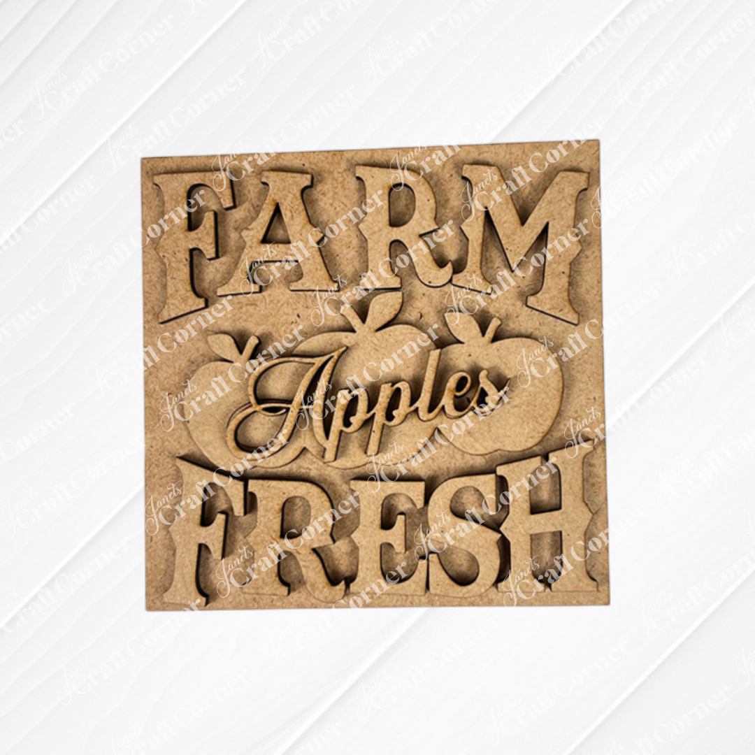 Janet's Craft Corner Farm Fresh Apples Square: Wooden sign with "FARM FRESH Apples" cutout letters and three apple shapes, ideal for DIY home decor in small spaces, displayed on a white textured surface.