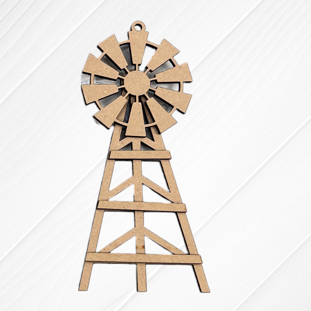 A flat, brown wooden windmill cutout from Janet's Craft Corner’s Farm Life Christmas Ornaments DIY kit (Choice of 4), perfect for farm-themed holiday décor, displayed on a white textured wood surface.