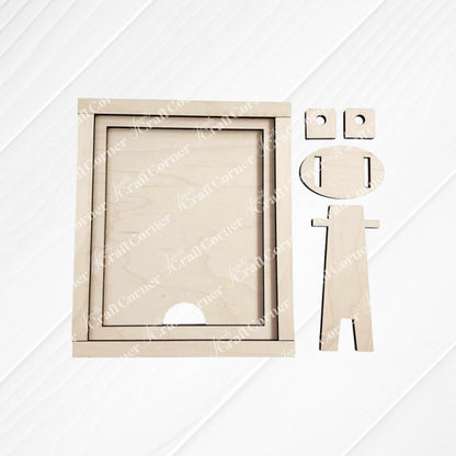 A wooden geometric figure resembling a person is positioned beside the Janet's Craft Corner Farmhouse Frame for Interchangeable Signs, which features two smaller circles on top. Set against a white, horizontally-lined background, this perfect addition to farmhouse decor has a round head with notches for eyes and mouth.