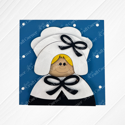 Harvest Blessings Thanksgiving Squares by Janet's Craft Corner feature whimsical wood cut-outs of a blonde girl in a white bonnet and cape with black bows, perfect for tiered tray decor, set on a blue background with white polka dots.