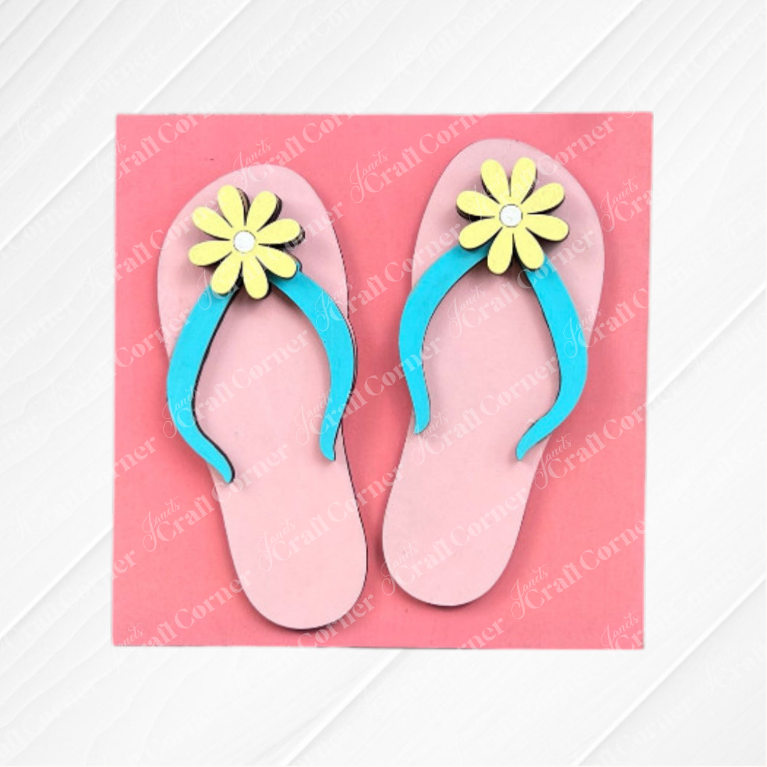 The Summer Lovin Swappable Squares DIY kit from Janet's Craft Corner features pink flip-flops with blue straps and yellow flowers on a pink background—perfect wood cut-outs for charming tiered tray decor.