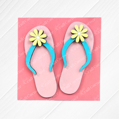 The Summer Lovin Swappable Squares DIY kit from Janet's Craft Corner features pink flip-flops with blue straps and yellow flowers on a pink background—perfect wood cut-outs for charming tiered tray decor.