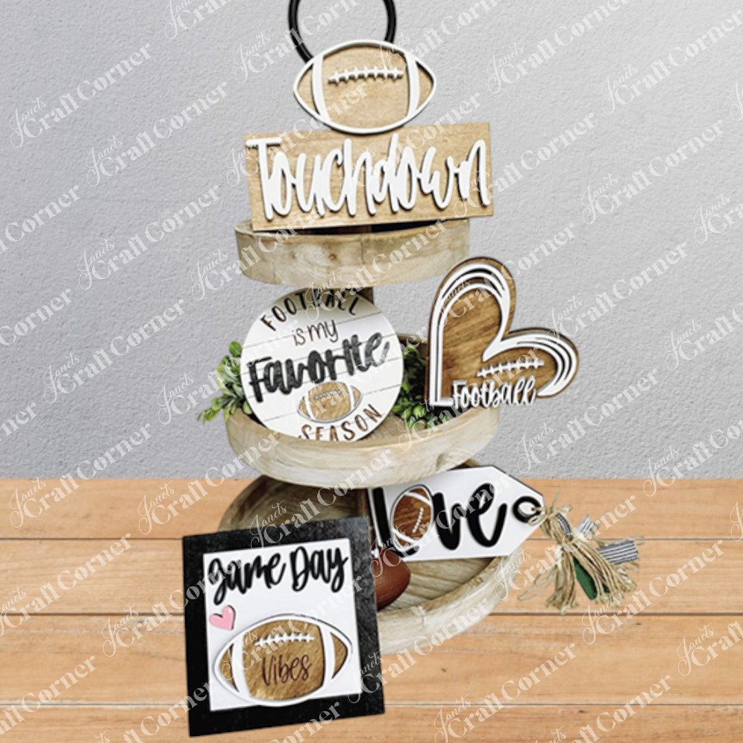Three-tiered wooden decorative tower with football-themed signs on a wooden surface.